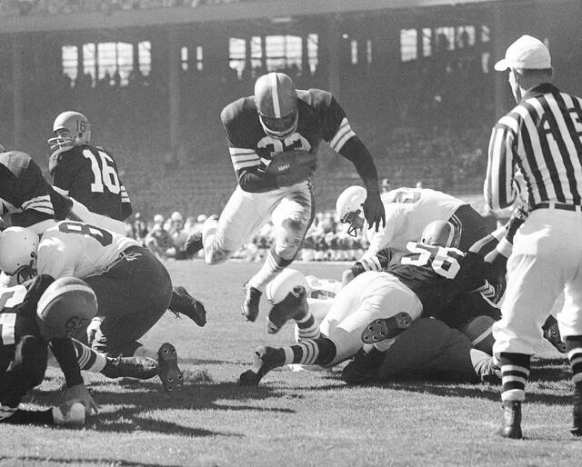 Fullback Jim Brown of the Cleveland Browns hurdles through a big hole for a 3-yard touchdown run in the first quarter of a football game against the Chicago Cardinals, Oct. 12, 1958 in Cleveland.