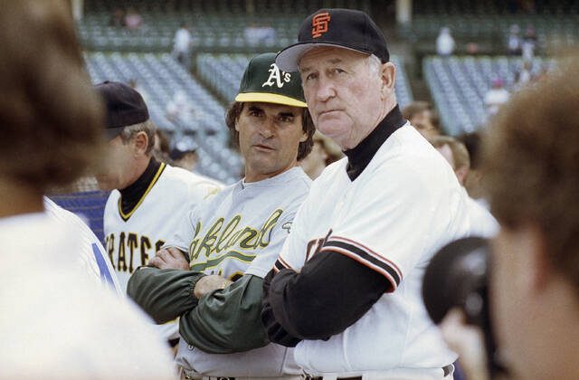 American League manager Tony La Russa, center left, from the Oakland A’s, and National League manager Roger Craig, of the San Francisco Giants, watch batting practice at Wrigley Field in Chicago, July 10, 1990, before the start of the 61st All-Star Game.