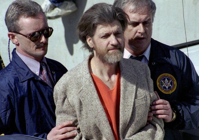 From April 4, 1996: Theodore “Ted” Kaczynski is flanked by federal agents as he is led to a car from the federal courthouse in Helena, Mont.