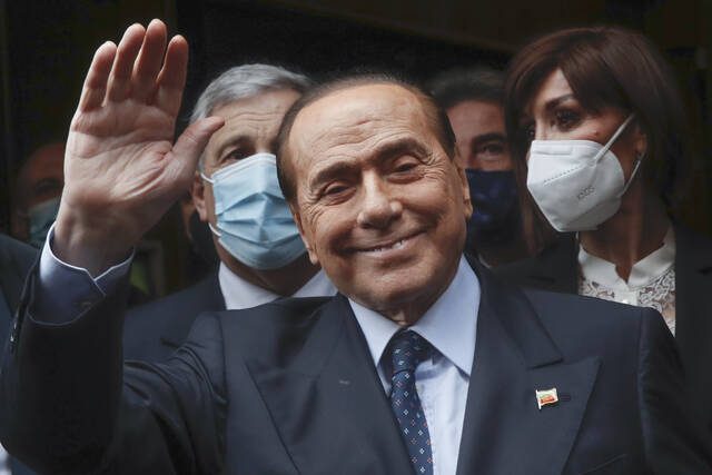 From Feb. 9, 2021: Former Italian Premier Silvio Berlusconi waves to reporters as he arrives at the Chamber of Deputies to meet Mario Draghi in Rome.