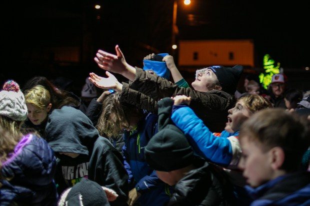 Dec. 7, 2023: Kids reach up to collect coins during the gelt drop with aid from the Mount Airy Volunteer Fire Company.The annual Chanukah Menorah lighting on Main Street in Mt. Airy, co-hosted by the Chabad Jewish Center of Carroll County. (Nate Pesce/ for Carroll County Times)