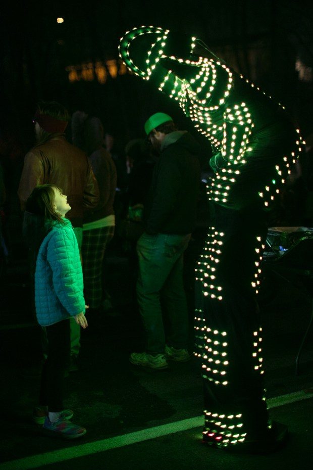 Dec. 7, 2023: Gwendolyn Warren, 7, of Mt. Airy, interacts with Cynthia Byrd, of Davey Productions, who is dressed as a light-up robot samurai on stilts.The annual Chanukah Menorah lighting on Main Street in Mt. Airy, co-hosted by the Chabad Jewish Center of Carroll County. (Nate Pesce/ for Carroll County Times)