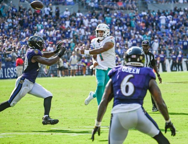 Dolphins quarterback Tua Tagovailoa throws a touchdown pass ahead of the rush of Ravens outside linebacker Odafe Oweh, left, on Sept. 22, 2022, at M&T Bank Stadium.