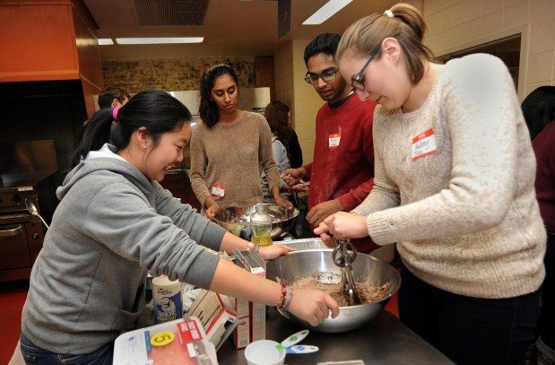 Baltimore, MD--January 18, 2016--Left to right: Volunteers: Lilly Su of Taiwan, Ash Panakam of Atlanta, Vijay Ramasamy of Kansas City and Audrey Garman of Seattle (all are Johns Hopkins University students) prepare a meal for the Baltimore Station program during the MLK Day of Service at Saints Phillip and James Catholic Church. Here, they make brownies in the church kitchen. Barbara Haddock Taylor/Baltimore Sun