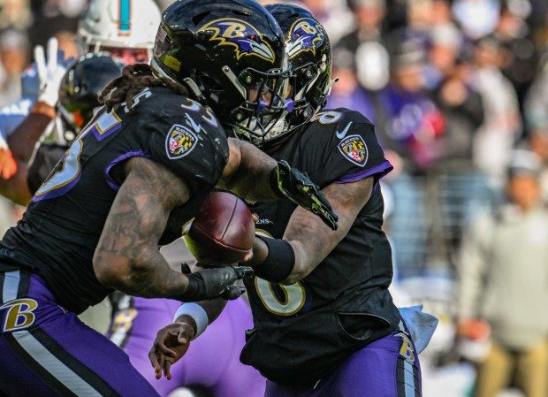 Dec. 31, 2023: Baltimore Ravens quarterback Lamar Jackson hands off to running back Gus Edwards in the 2nd quarter against the Miami Dolphins at M&T Bank Stadium. The Ravens defeated the Dolphins 56-19. (Jerry Jackson/Staff photo)