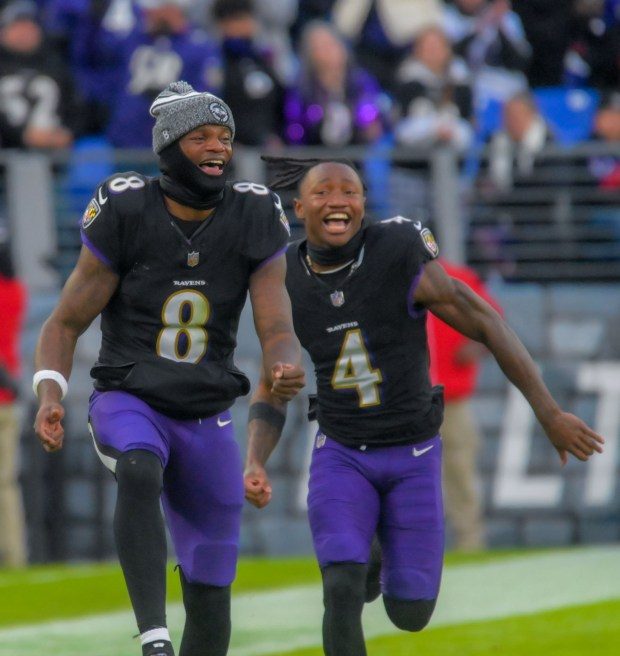 With the game in hand, Baltimore Ravens quarterback Lamar Jackson (8) and wide receiver Zay Flowers react after quarterback Tyler Huntley connects with tight end Charlie Kolar for his first career touchdown during the fourth quarter of an AFC matchup of NFL football in Baltimore. The Ravens became the AFC North champions, securing home field advantage throughout the playoffs with their 56-19 drubbing of Miami. (Karl Merton Ferron/Baltimore Sun Staff)