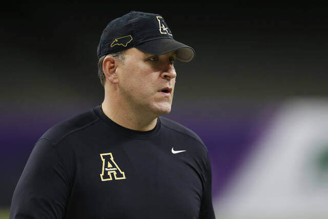 Appalachian State coach Shawn Clark watches players warm up before taking on UAB in the New Orleans Bowl NCAA college football game in New Orleans.